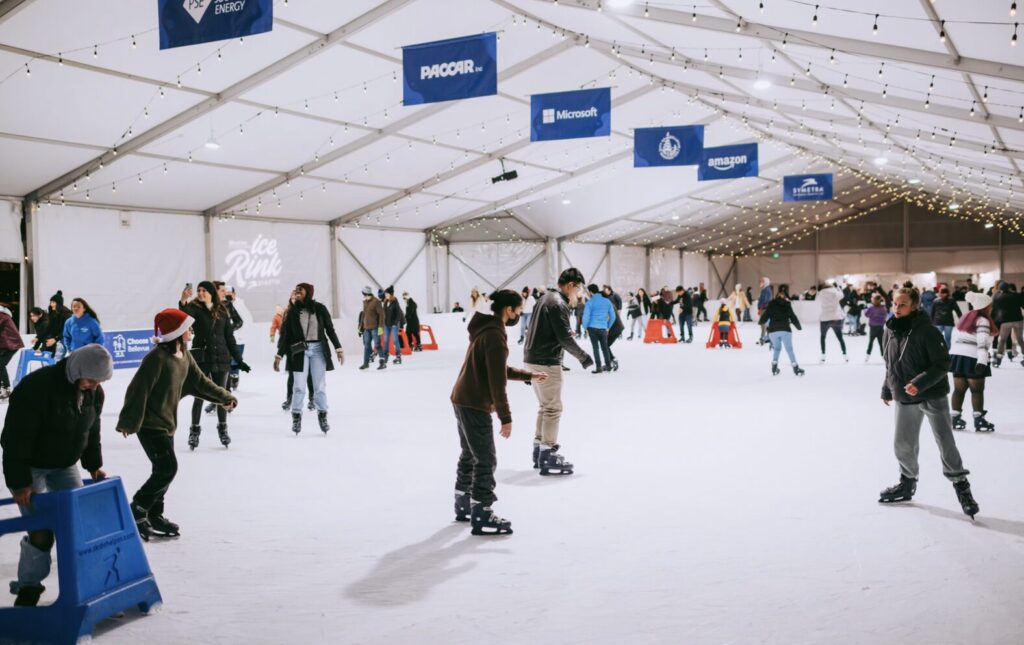 Families ice skating under holiday lights at Bellevue Downtown Park 2025